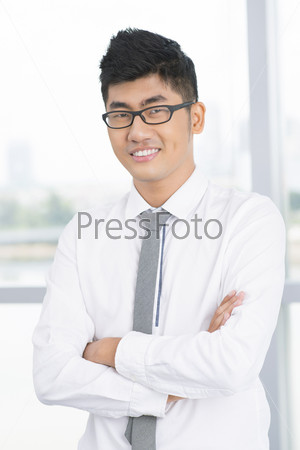 Vertical portrait of a young successful businessman building his career in a big corporation