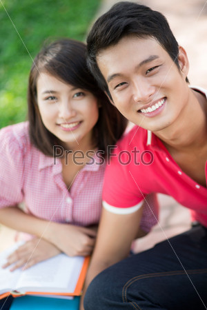 Handsome guy smiling at camera with his girlfriend