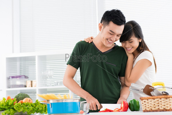 Married couple enjoying their time at home cooking