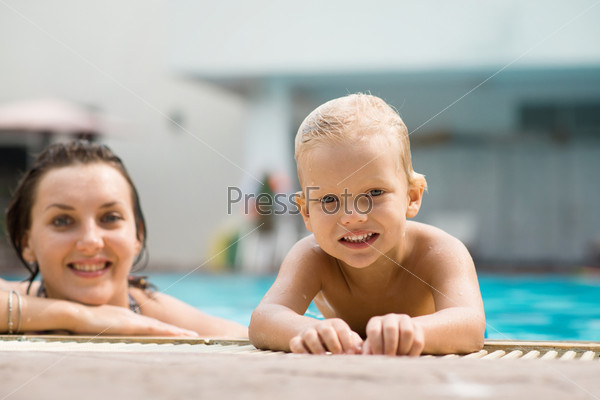 Portrait of happy mom and son enjoying pool leisure