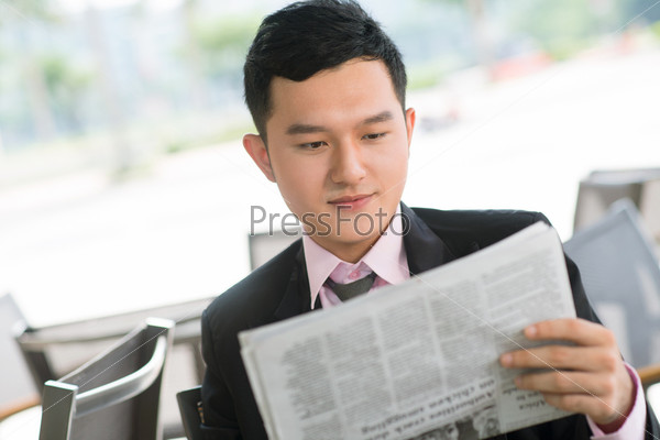 Young manager spending time reading business news