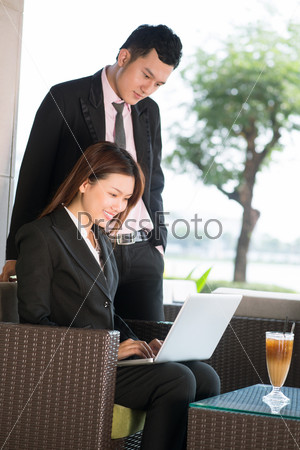 Vertical image of a business supervisor reviewing the presentation of his intern