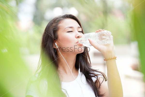 Young lady drinking water from the bottle