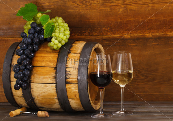 Still life with glasses of red and white wine, barrel with grapes