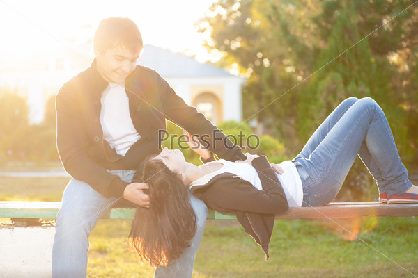 Happy couple against the background of autumn park, backlit composition, togetherness concept, love and tenderness, stock photo
