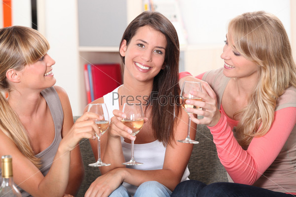 Three girlfriends drinking wine together