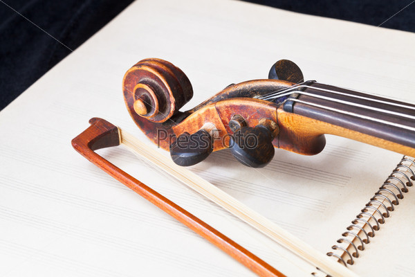 violin bow and scroll on music book