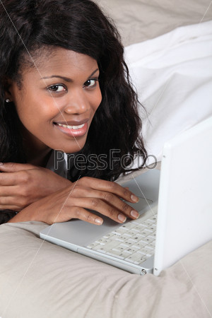 woman having fun with her laptop in bed