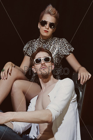 Studio portrait of young men and women wearing a stylish sunglasses on black background