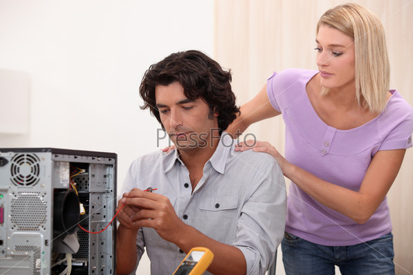 Technician repairing PC for attractive colleague, stock photo