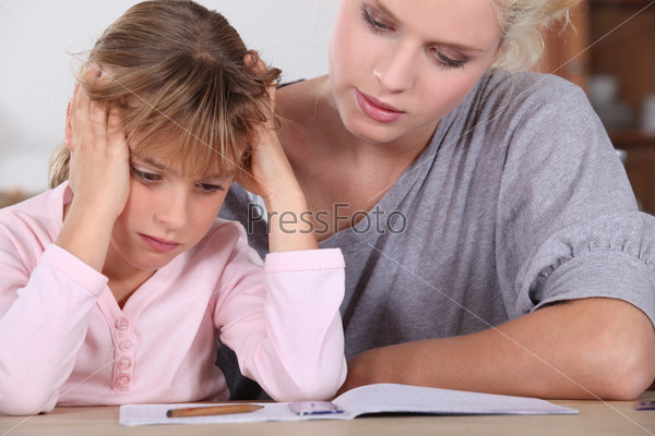 Мать и маленькая девочка делают домашнее задание