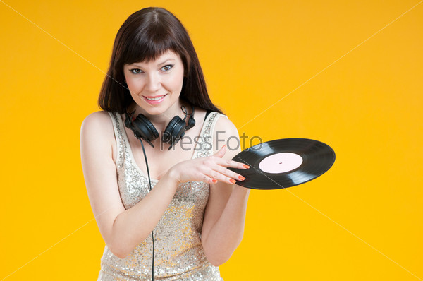 Attractive female DJ holding a vinyl record, studio shot