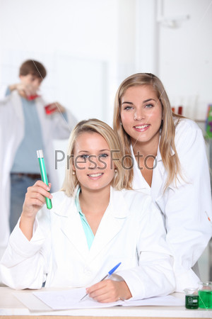 Chemistry students with a test tube containing green liquid