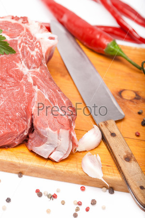 fresh meat of beef with bone on wooden with spices and knife