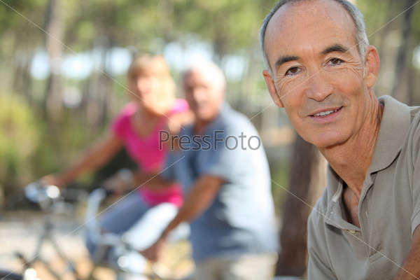 Three middle-aged people on bike ride, stock photo