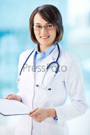 Vertical portrait of a lovely general practitioner holding document