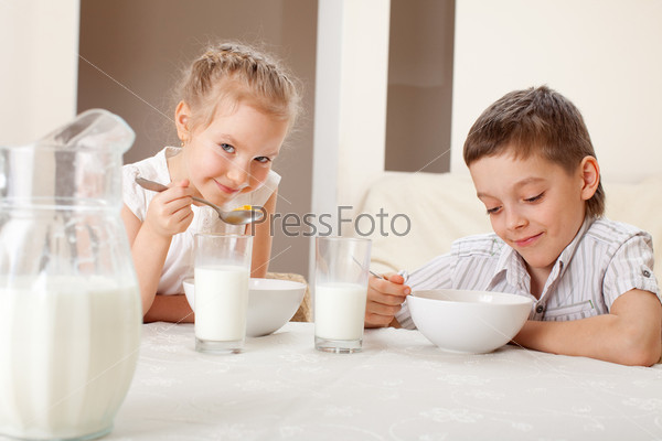 Children eat breakfast. Family eating cereals with milk