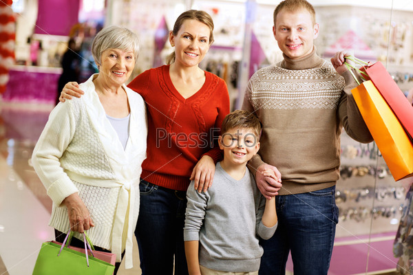 Portrait of happy family during shopping in the mall looking at camera