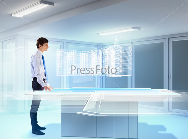 young businessman looking at high-tech image of building\
model