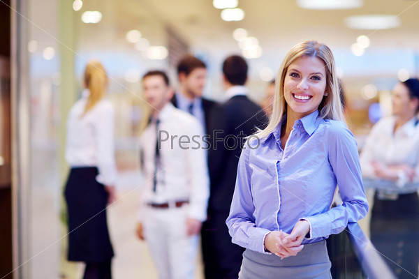 Business Woman With Her Staff, People Group In Background At Modern Bright Office Indoors