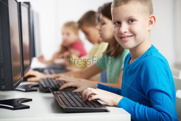 Portrait of smart lad looking at camera at computer lesson