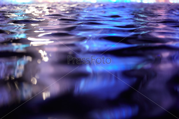 Blue and violet water surface with light reflection abstract background.
