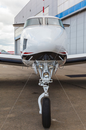 White reactive private jet, the front landing gear on blue sky and clouds