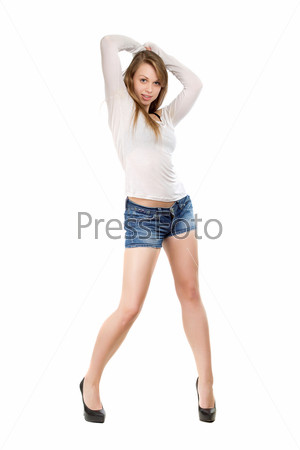 Pretty leggy blond woman wearing blue jeans shorts, white blouse and black shoes. Isolated