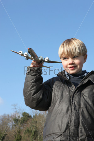 Маленький мальчик с игрушечной моделью самолета в руке