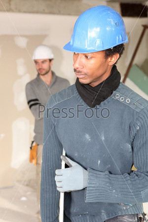 Two men carrying plaster board