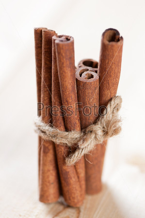 Vertical shot of a cinnamon bundle on a wooden background, close-up
