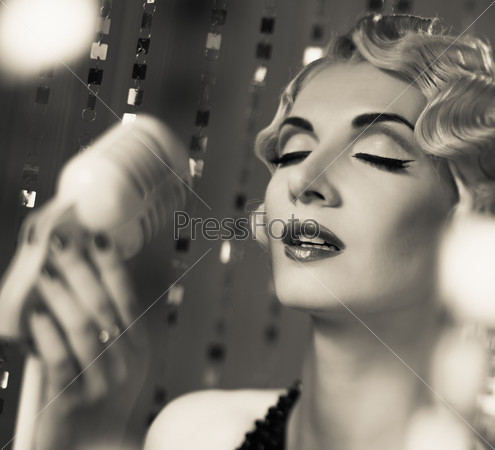 Monochrome portrait of elegant blond retro woman singer with beautiful hairdo
