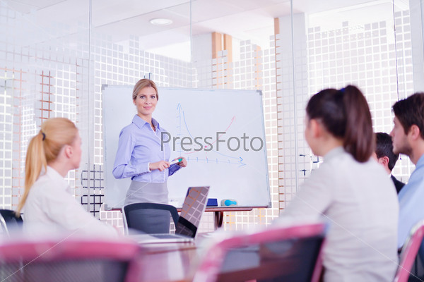 Business woman with her staff in background at office