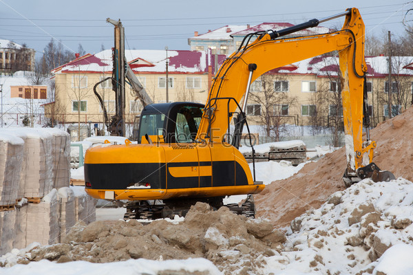 Construction of a new home. Preliminary work. Excavator digs a hole