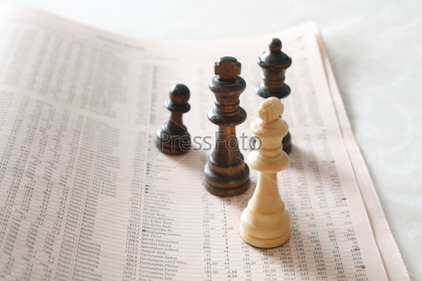 Chess pieces on top of business newspaper, stock photo