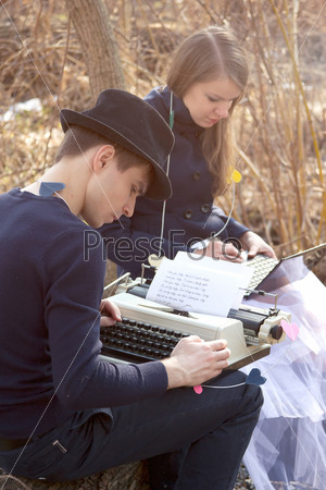 Молодой человек печатает на пишущей машинке