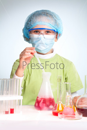 A little girl looking at camera while making chemical experiment
