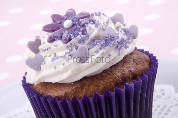 cocoa cupcake with lilac flower and sugar sprinkles