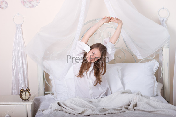 Young girl stretching in bed