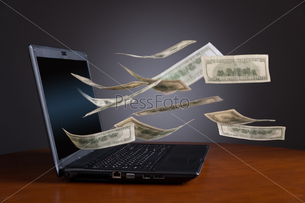 Money falling out from laptop, blurred motion