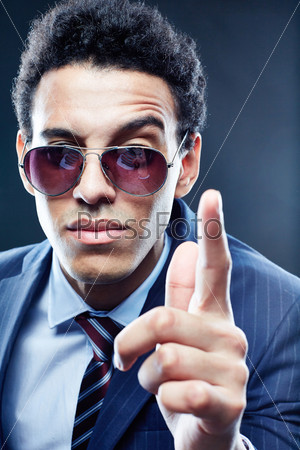 Vertical portrait of a cool businessman wagging his finger