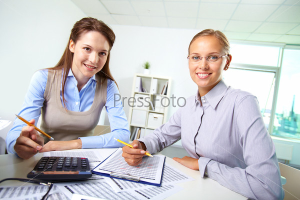 Portrait of happy female colleagues accounting in office