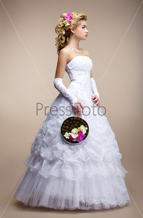 Wedding Style. Bride wearing White Dress and Gloves. Trendy Bouquet of Flowers
