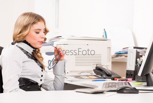 Young business woman sitting in front of computer monitor in office