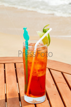 Americano cocktail with ice on the table against the background of sea and sky