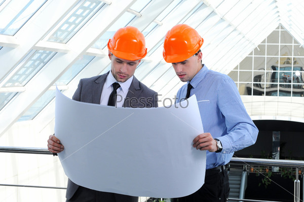 Двое мужчин в касках на строительной площадке