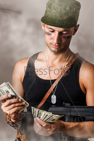 Handsome sexy military man with automatic counting the money
