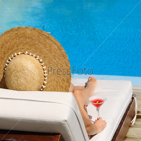 Woman at poolside with cosmopolitan cocktail