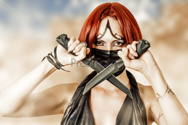 Sexy dangerous woman in black mask with two hunting knifes