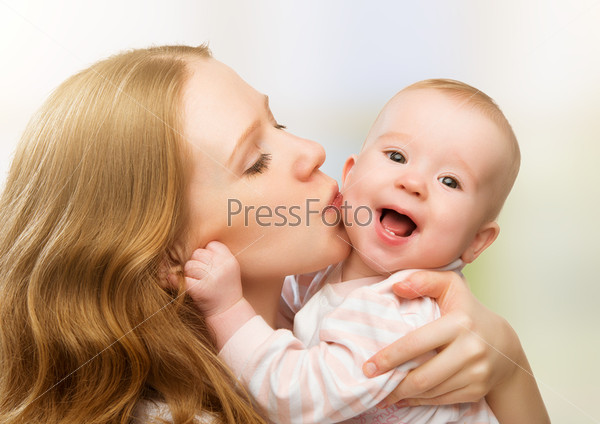 Happy cheerful family. Mother and baby kissing, laughing and hugging, stock photo